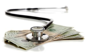 A stethoscope and American money on a white background - Healthcare cost concept