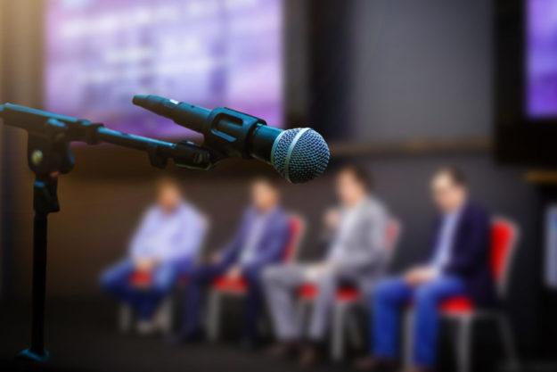 Microphone in front businesspeople blurred in conference meeting room