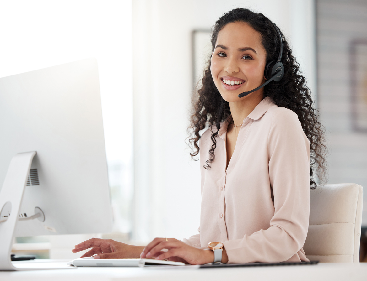 Portrait of a young call centre agent working on a computer in an office