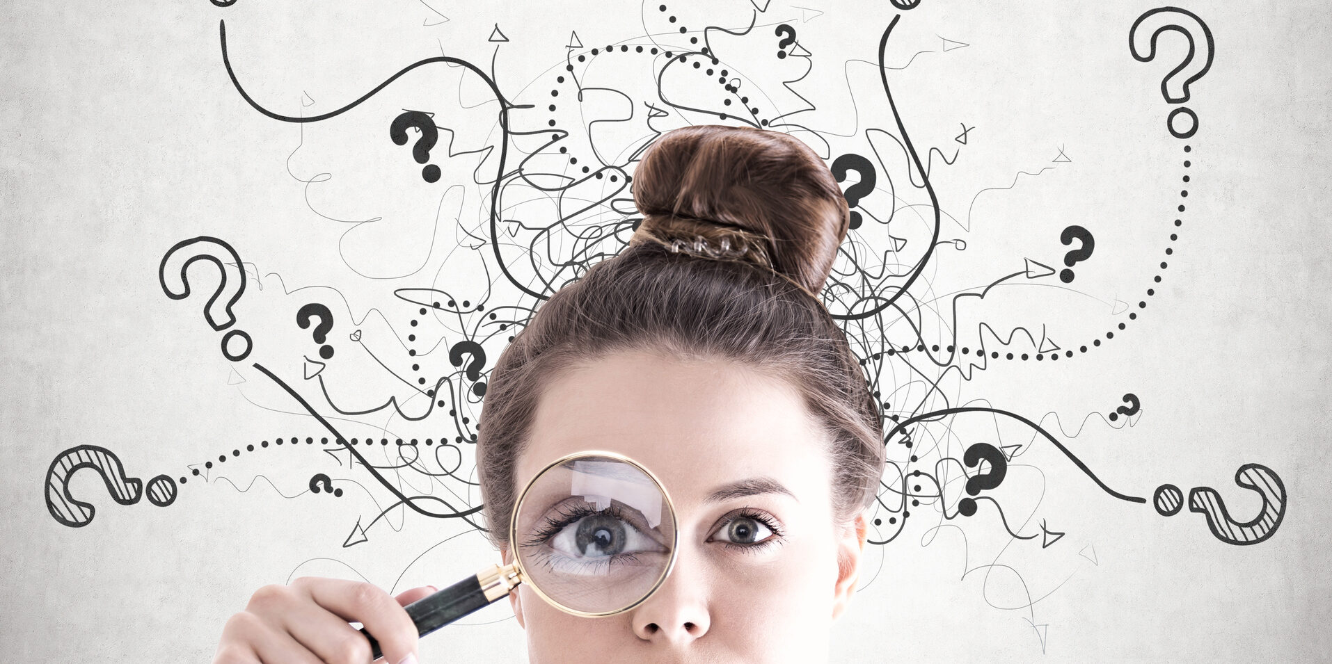 Woman looking through magnifying glass with question marks around her head.
