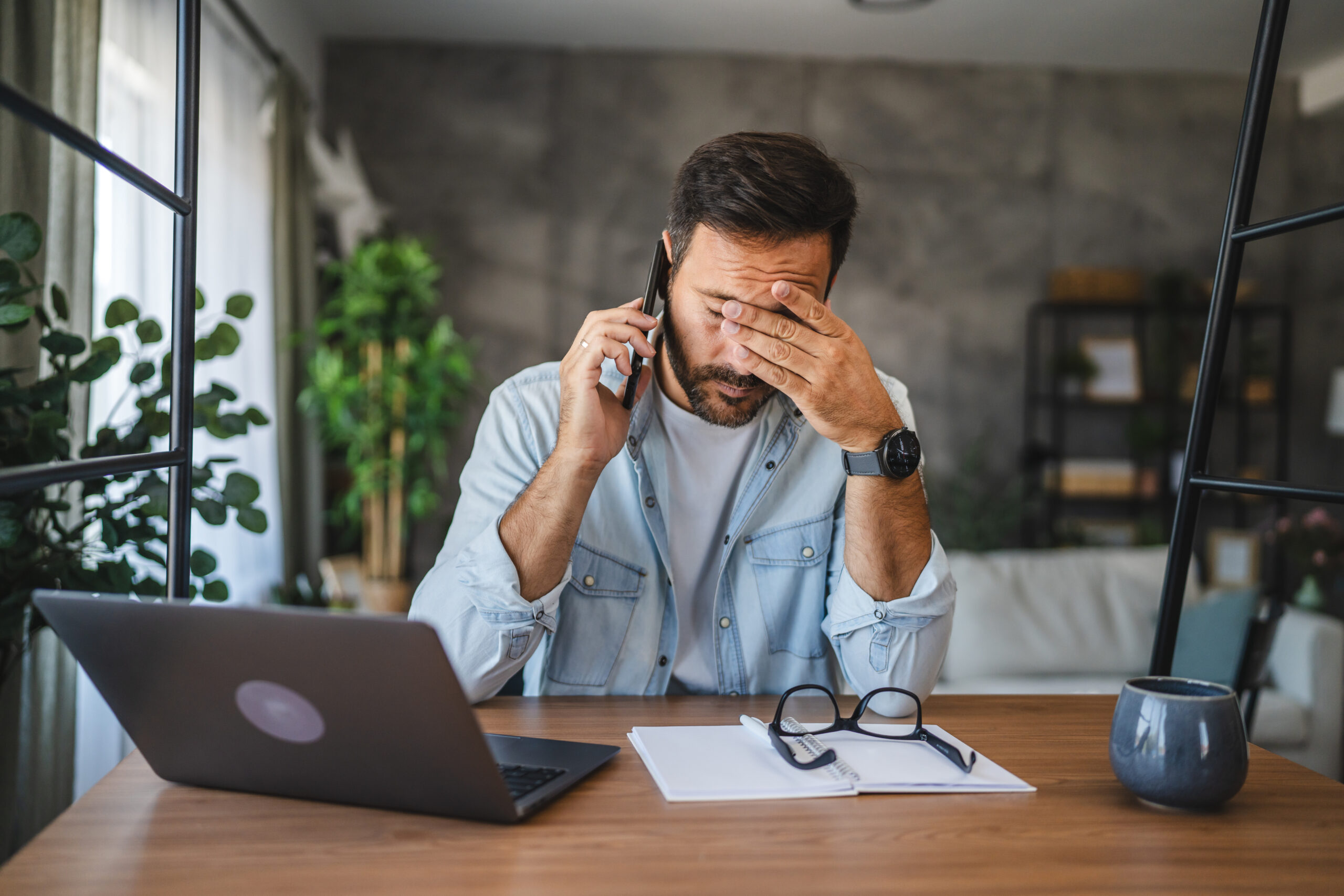 Adult exhausted, tired man talk on mobile phone at home