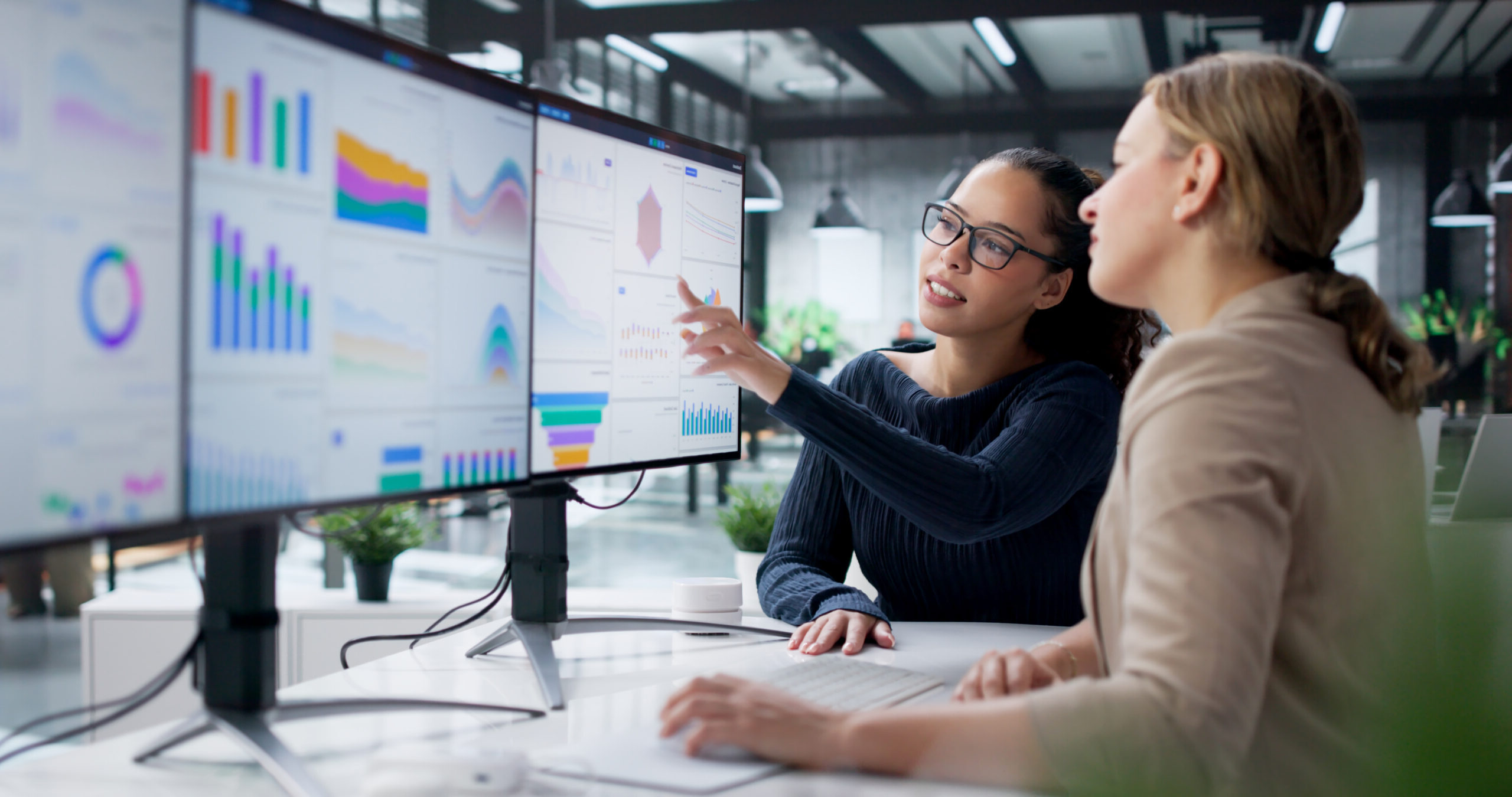 Businesswomen Analyzing Financial Data On Computer Screen