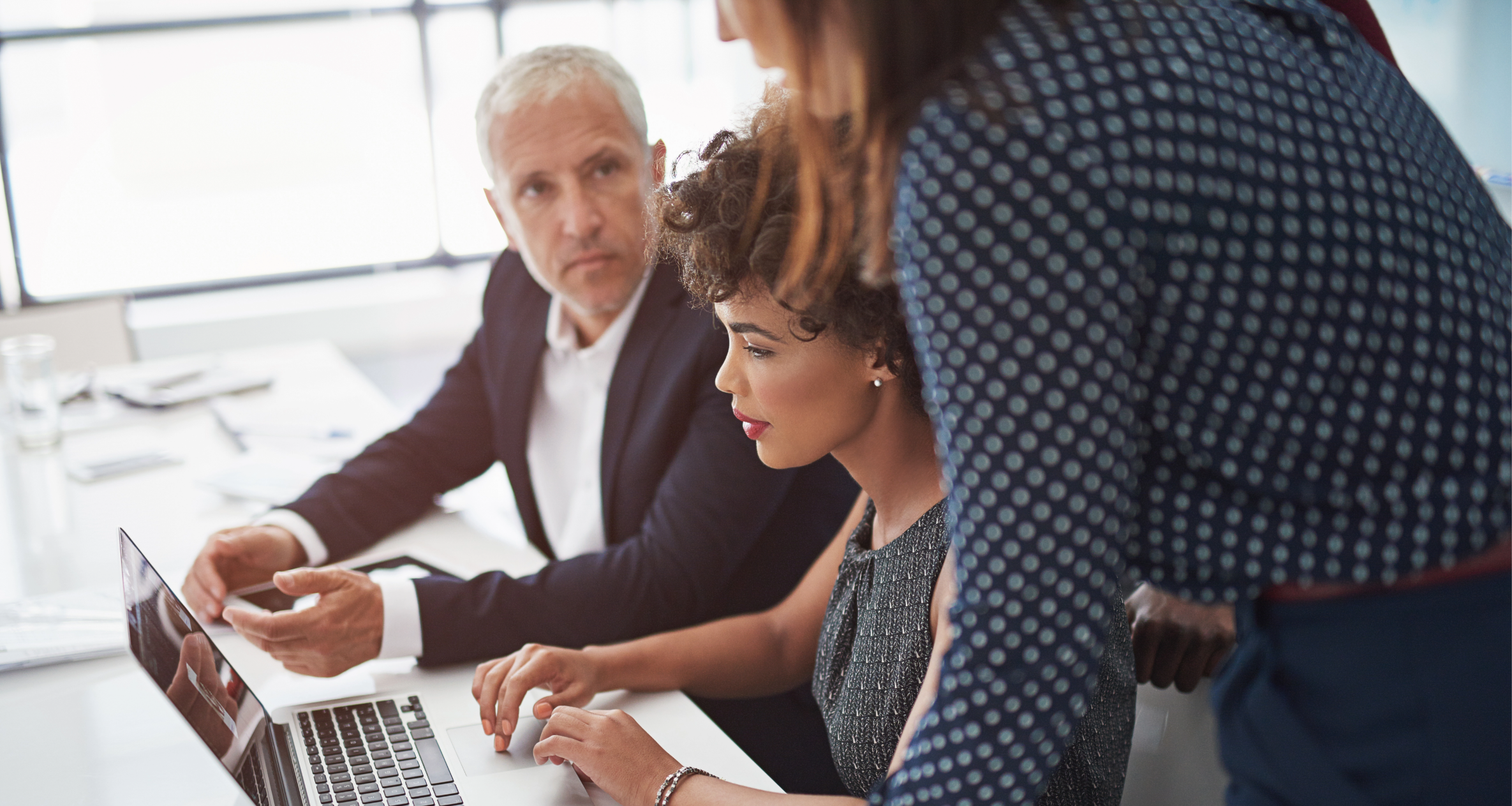 Cropped shot of a diverse group of businesspeople discussing something on a laptop.