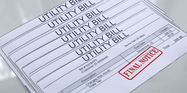 Stack of final notice Utility bills on table.