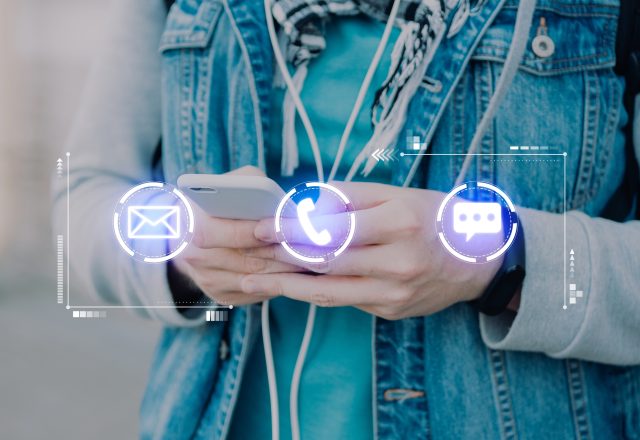 The concept of contacts via phone, mail, instant messengers. A man holds a smartphone.